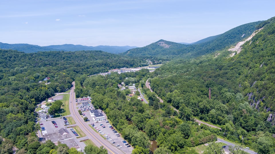 A mountainous landscape with a parking lot and a road.