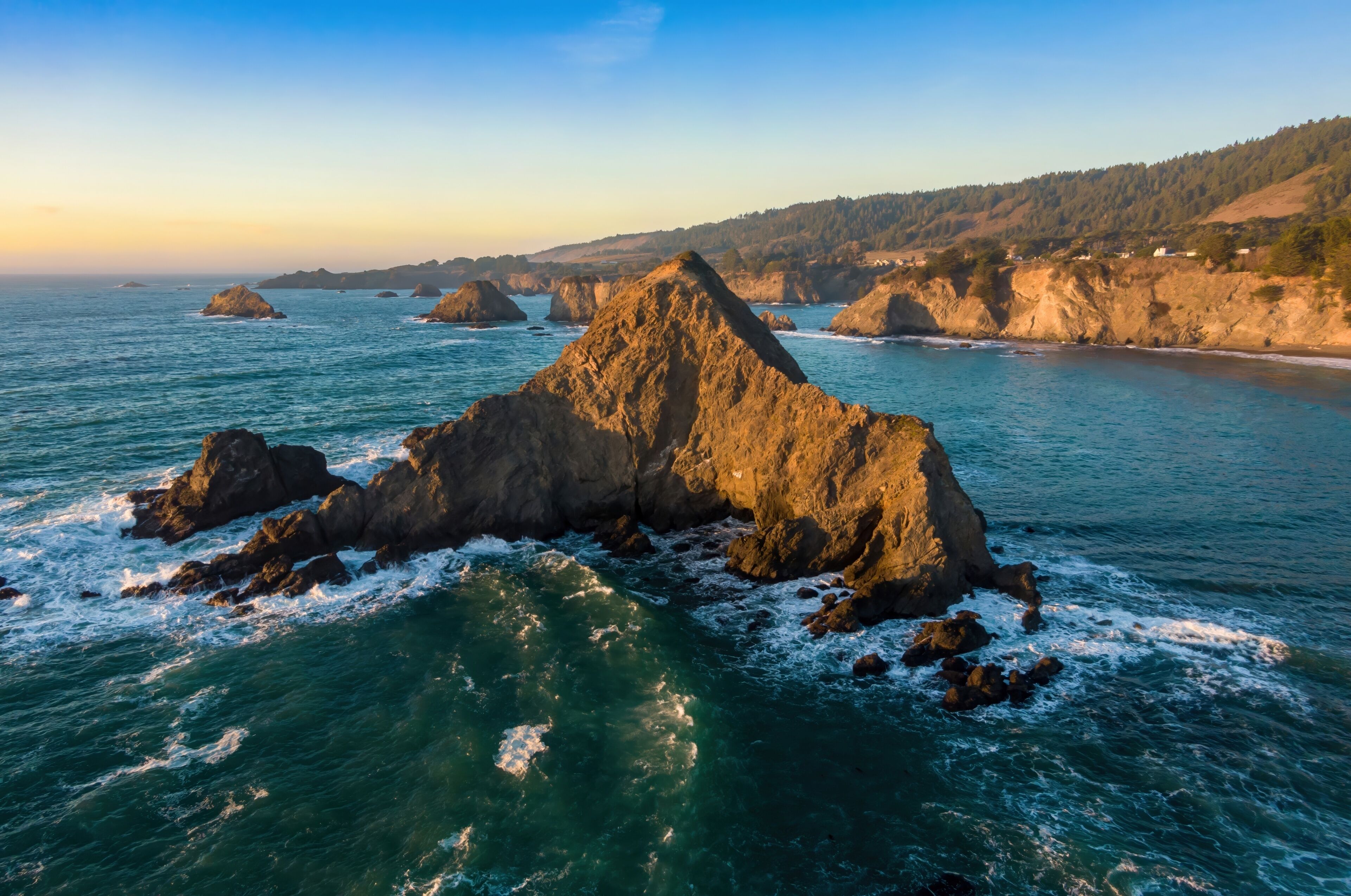 Coastal landscape of Northern California, USA, featuring rugged cliffs and sea stacks along the Pacific Ocean in Greenwood Creek State Beach, Elk, California, USA. Waves crash against the rocks