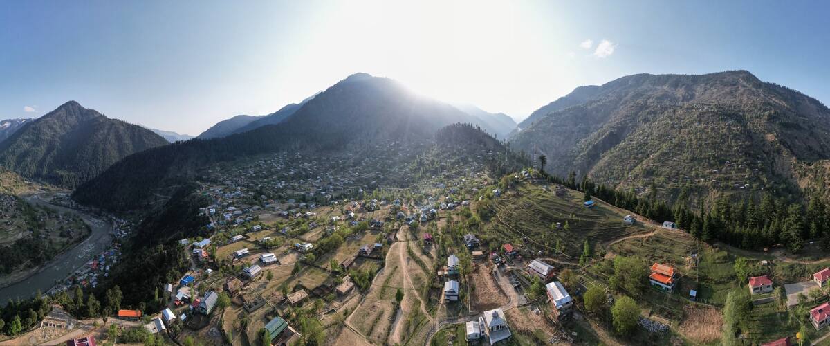 A mountainous landscape with a river, terraced fields, and scattered houses.