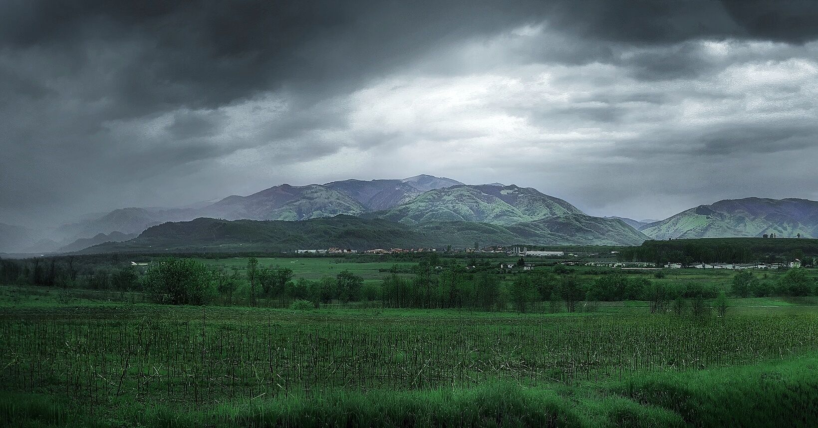 A mountainous landscape with a village in the valley.