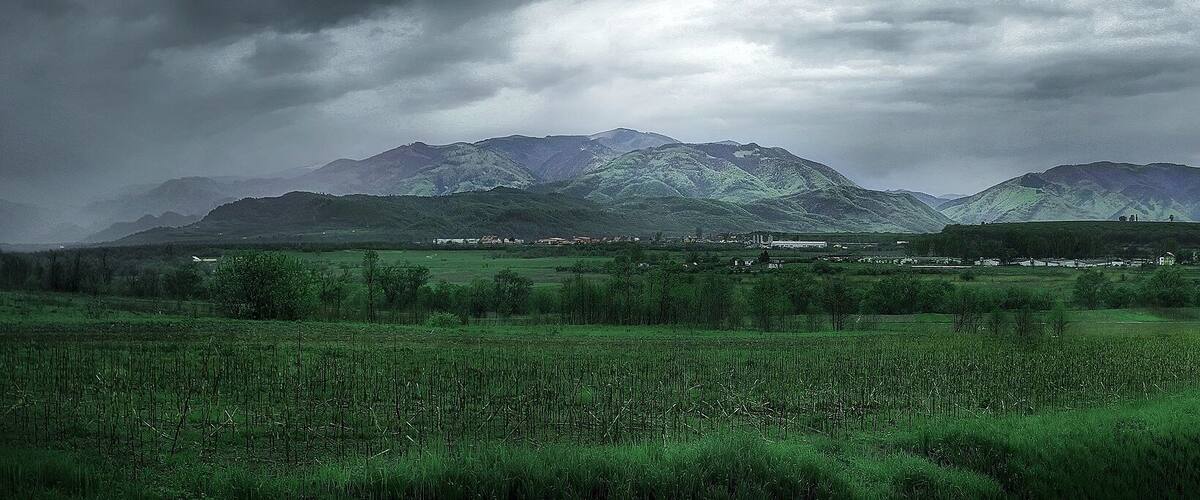 A mountainous landscape with a village in the valley.
