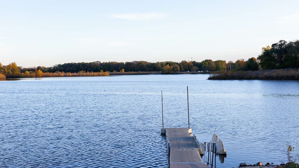 A calm lake with a wooden dock extending into the water.