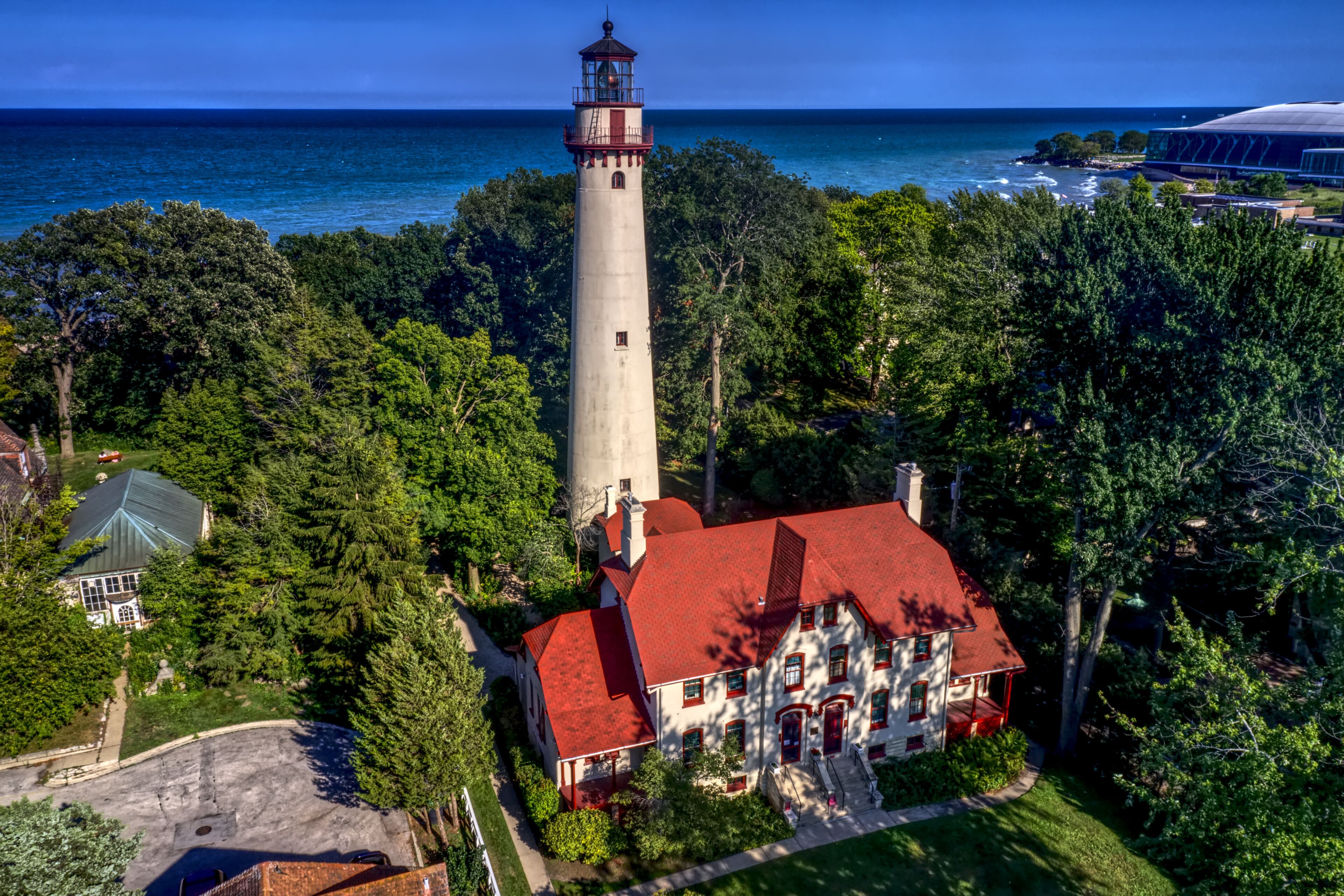 A lighthouse, a red-roofed house, and a coastal view.