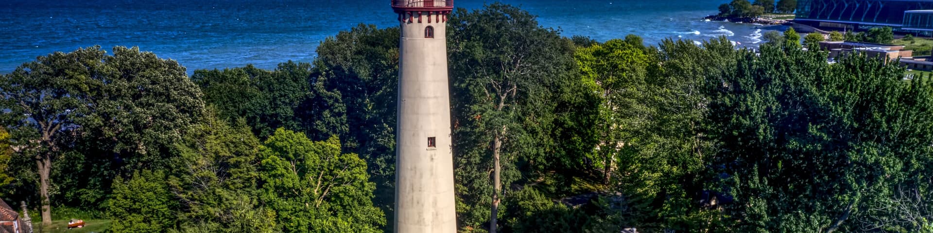 A lighthouse, a red-roofed house, and a coastal view.