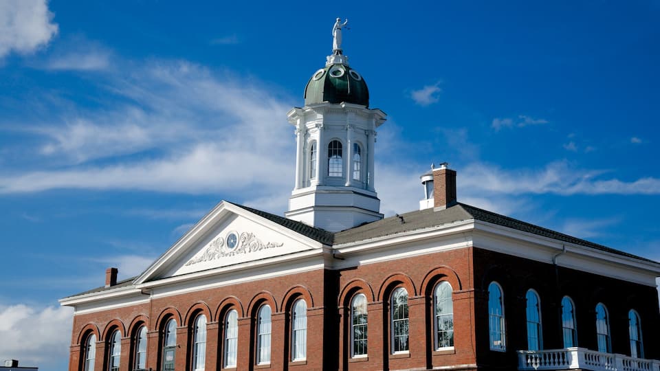 A historic building with a prominent clock tower and arched windows.