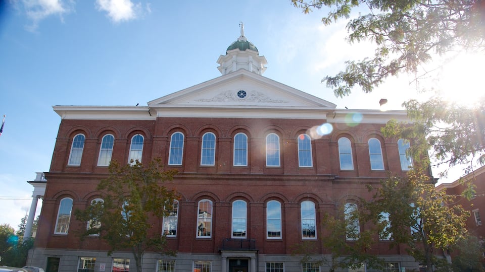 A large red brick building with a green dome and arched windows.