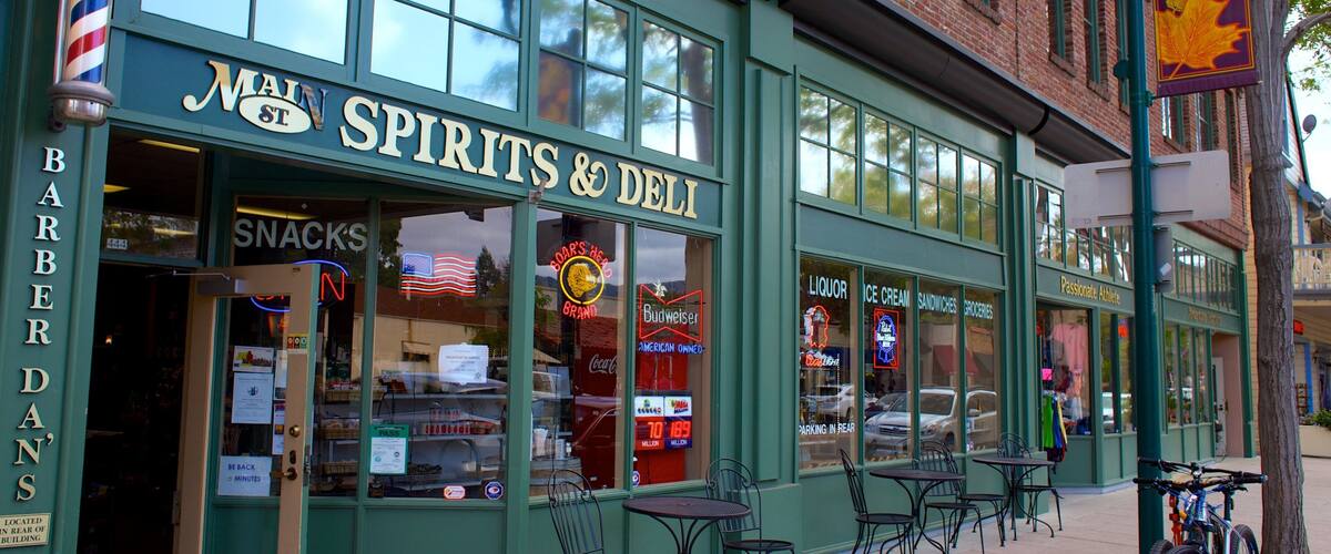 A storefront with 'Main Spirits & Deli' signage, outdoor seating, and a barber shop named 'BarberDan's' adjacent to it.