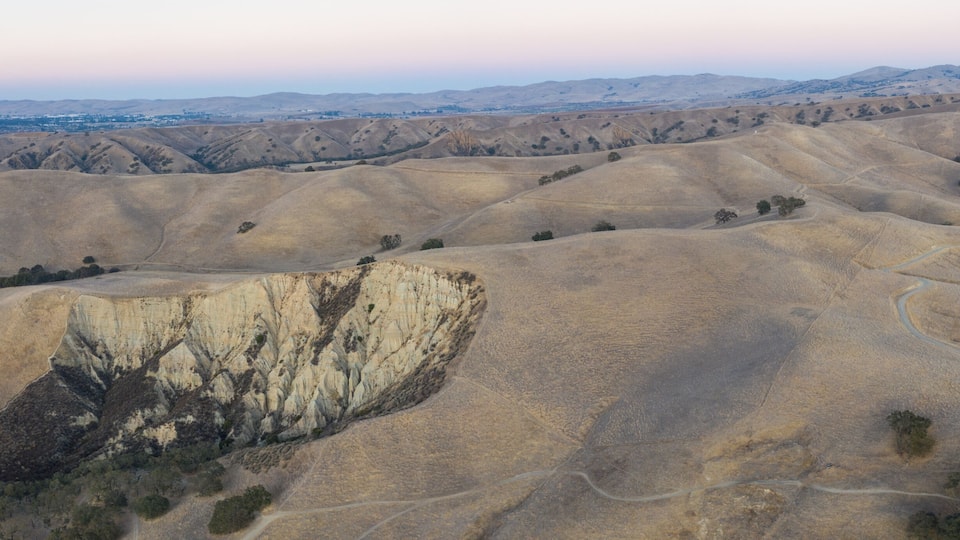 Rolling hills with a prominent cliff face.