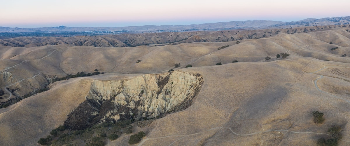 Rolling hills with a prominent cliff face.