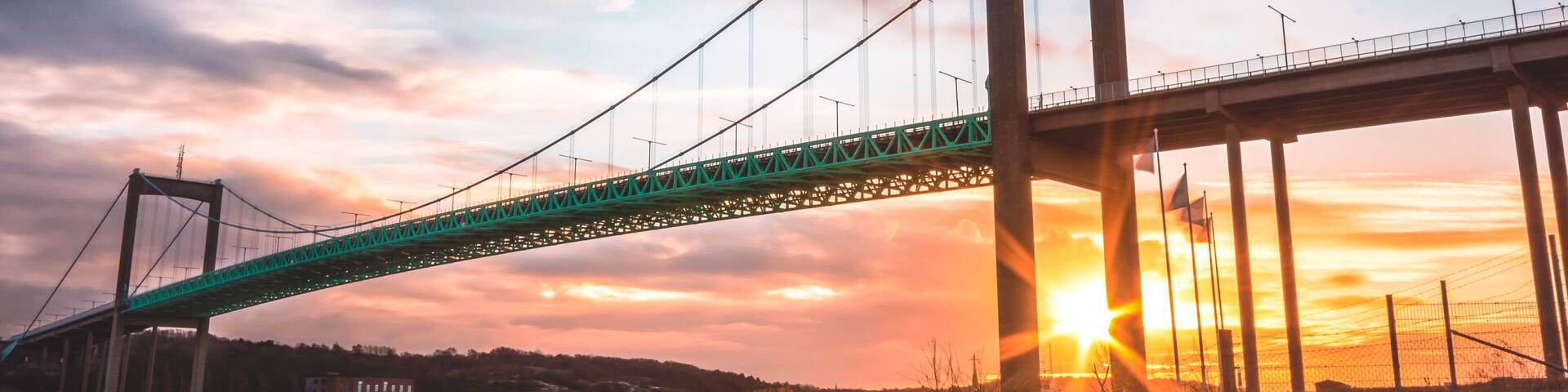 Suspension bridge at Gothenburg Connecting main land to Industrial area of Hisingen in west coast of Sweden. Setting sun creating star in between pillars of bridge
