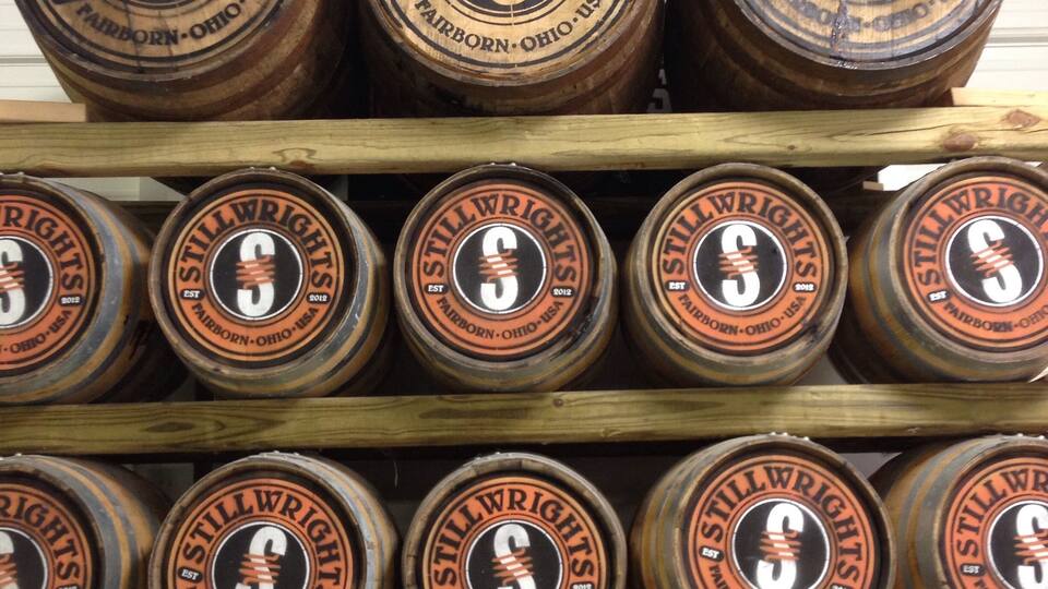A wooden rack with multiple Stillwrights beer kegs.