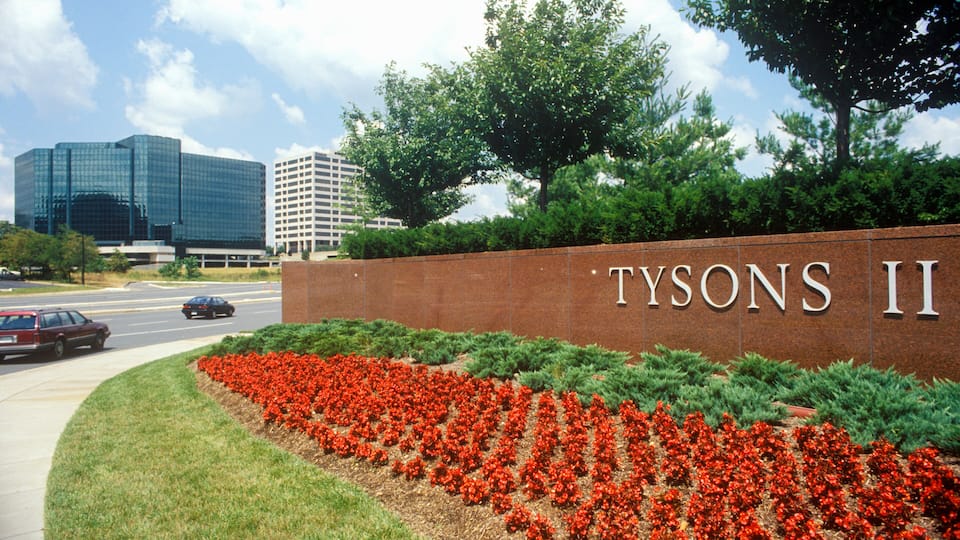 A landscaped area with a brick wall and the text "TYSONS II" on it.