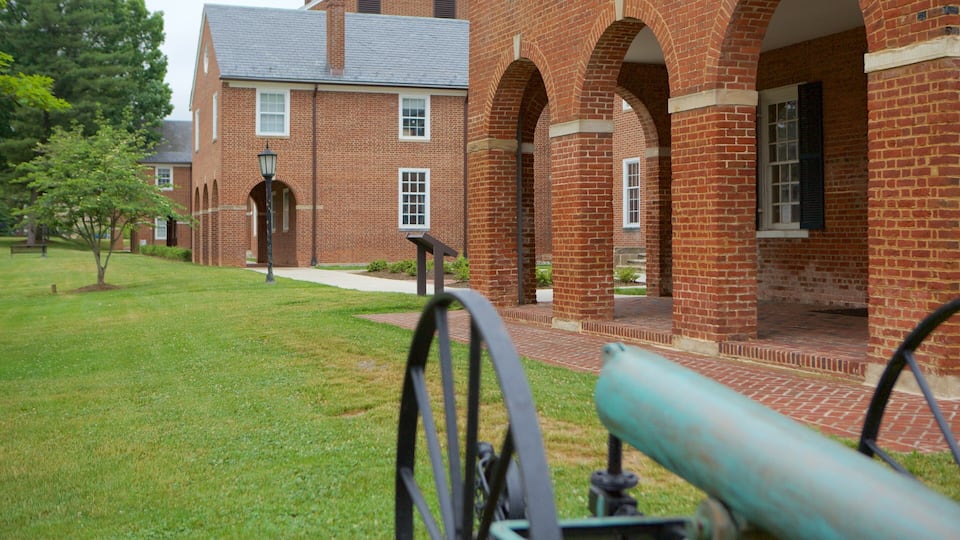 A brick building with arched walkways and a lawn.