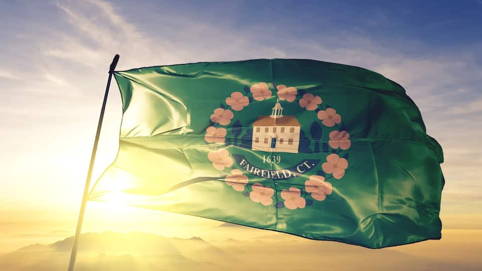 A flag with a building and flowers, and the text "1639 FAIRFIELD, CT."