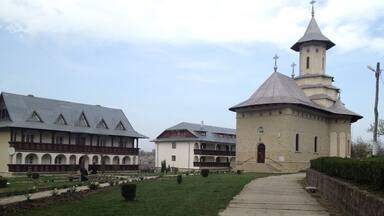 A courtyard with a pathway leading to a church with a tower.