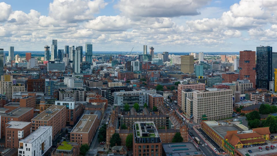Aerial view of Manchester’s skyline with clustered tall modern towers photographed over Ancoats area.