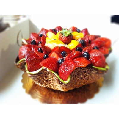 Fresh fruits (blueberries, apples, pineapple, peaches, strawberries) with strawberry mousse and pastry cream in florentine shell made with almonds, sugar and sesame seeds.