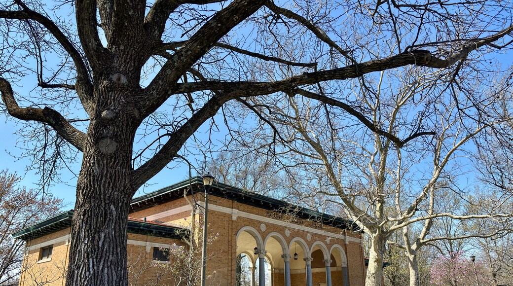Historic brick pavilion with arched columns in early spring park