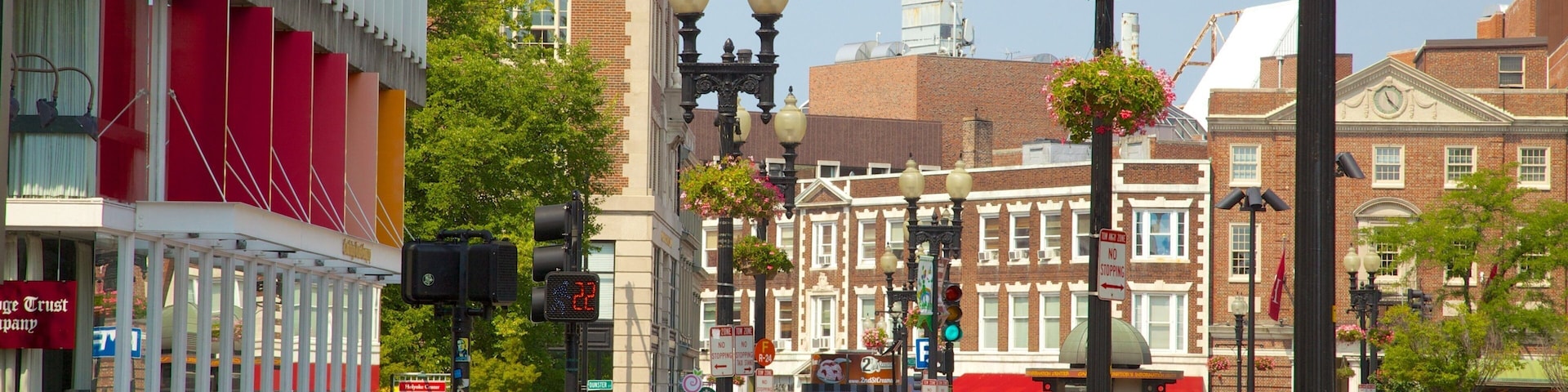 A busy urban street with pedestrians, cars, and historic buildings.