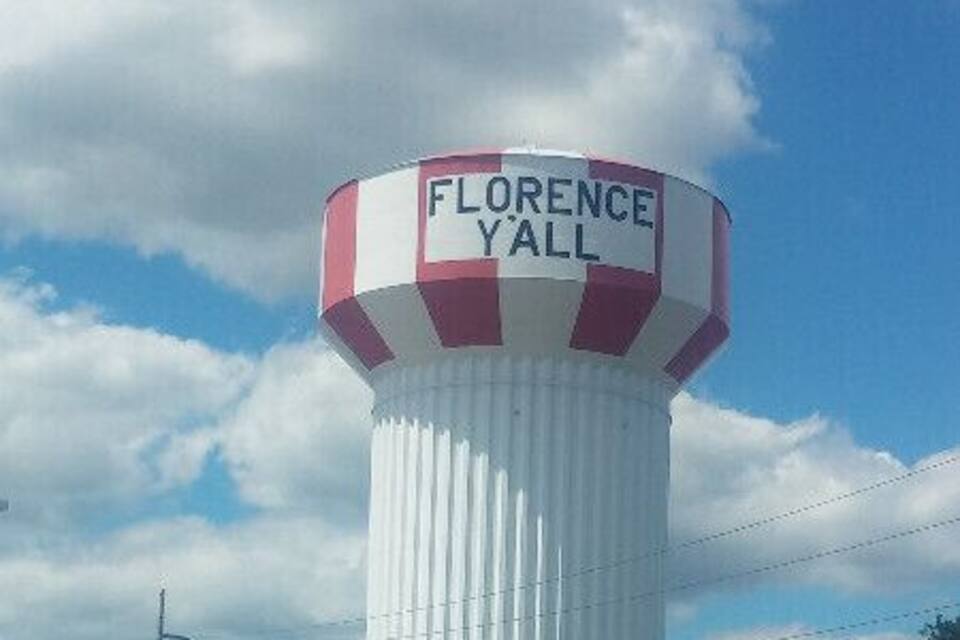 A tall water tower with the inscription "Florence Y'all" on its top.
