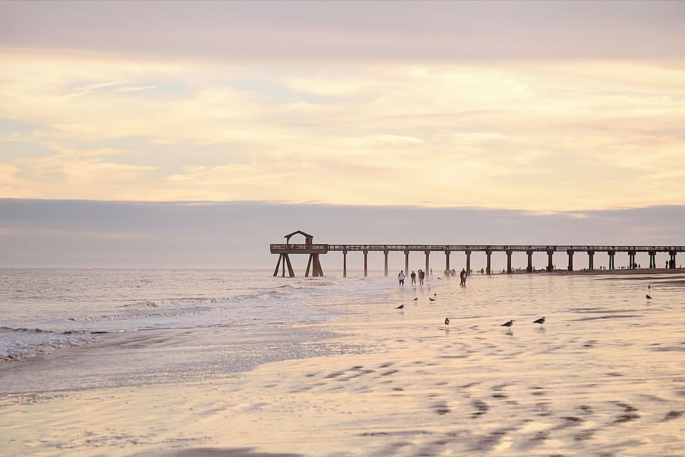 A pier extending into the ocean with people walking along it.