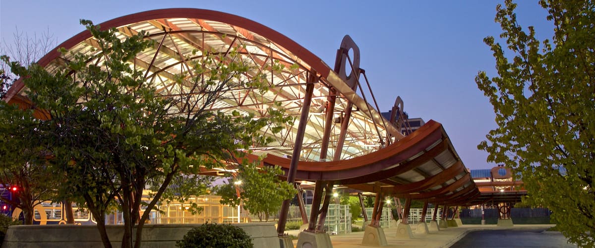 A large, modern stadium with a curved roof and metallic structure.