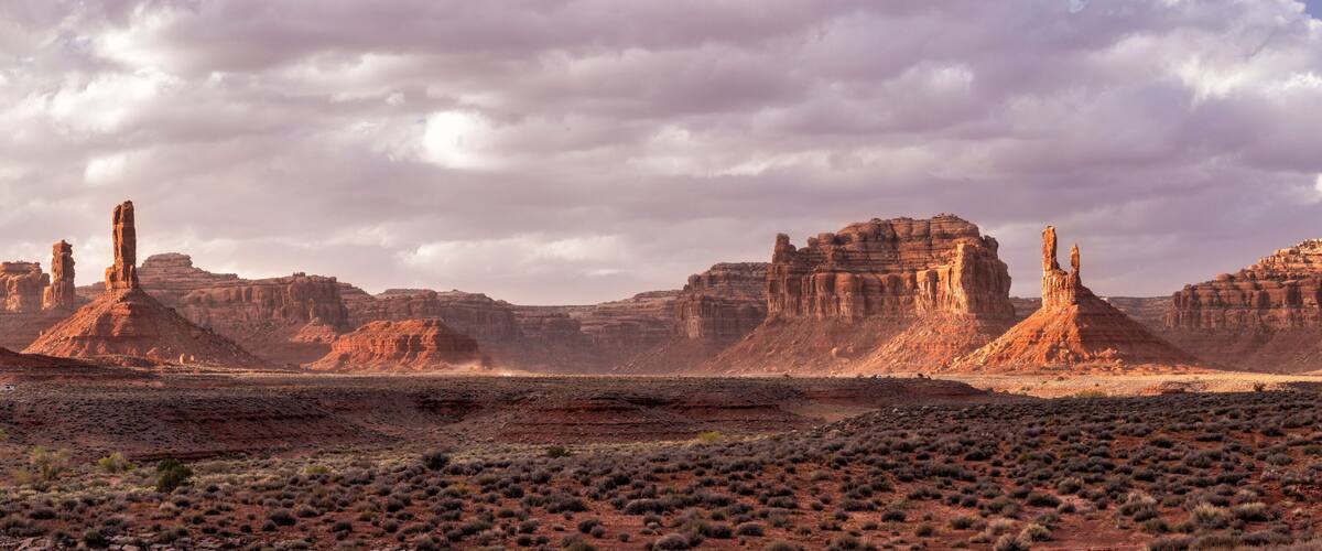 A desert landscape with prominent rock formations and sparse vegetation.