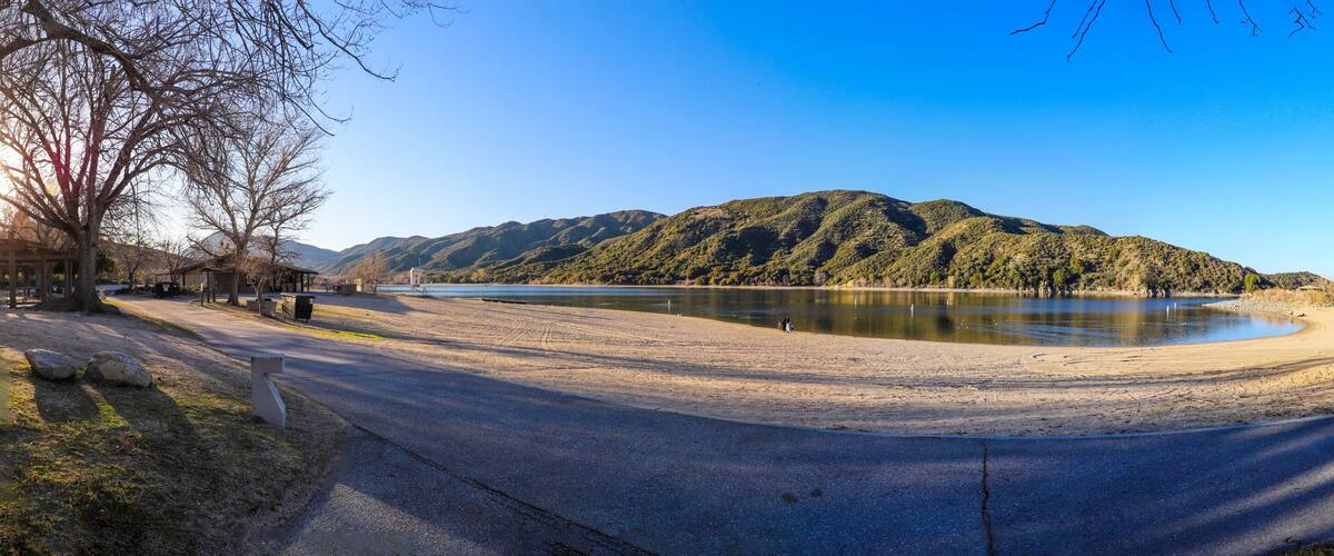 a stunning panoramic shot of the still lake water and majestic mountain ranges reflecting off the lake water at Silverwood Lake in San Bernardino County Hesperia California USA