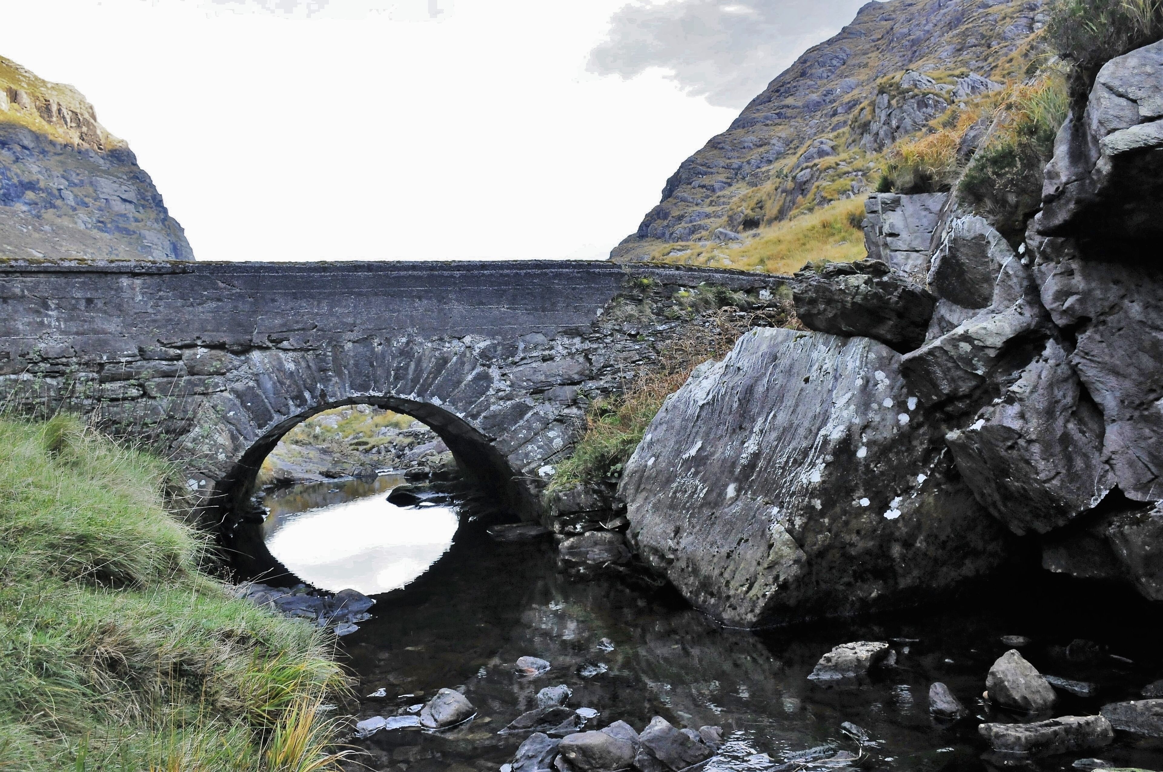 There are several stone bridges along the way that tourists can't get enough of,
The Gap of Dunloe is a narrow mountain pass forged between the MacGillycuddy Reeks and Purple Mountain by glacial flows. The river running through the gap is the river Loe from where the Gap gets its name. The Gap begins at Kate Kearney's Cottage. The road, narrow in many places, winds through the pass and descends into The Black Valley passing five lakes, Coosaun Lough, Black Lake, Cushnavally Lake, Auger Lake and Black Lough. Within easy walking distance from Kate Kearney's cottage is a picturesque old bridge known as the 'Wishing Bridge'. It is said that wishes made here really do come true!
The Gap is approximately 11 km from north to south. You can hire a jaunting car (horse drawn wagon) to travel through the Pass and take a boat back to Killarney from Lord Brandon's cottage at the other end.