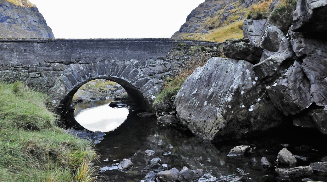 There are several stone bridges along the way that tourists can't get enough of,
The Gap of Dunloe is a narrow mountain pass forged between the MacGillycuddy Reeks and Purple Mountain by glacial flows. The river running through the gap is the river Loe from where the Gap gets its name. The Gap begins at Kate Kearney's Cottage. The road, narrow in many places, winds through the pass and descends into The Black Valley passing five lakes, Coosaun Lough, Black Lake, Cushnavally Lake, Auger Lake and Black Lough. Within easy walking distance from Kate Kearney's cottage is a picturesque old bridge known as the 'Wishing Bridge'. It is said that wishes made here really do come true!
The Gap is approximately 11 km from north to south. You can hire a jaunting car (horse drawn wagon) to travel through the Pass and take a boat back to Killarney from Lord Brandon's cottage at the other end.
