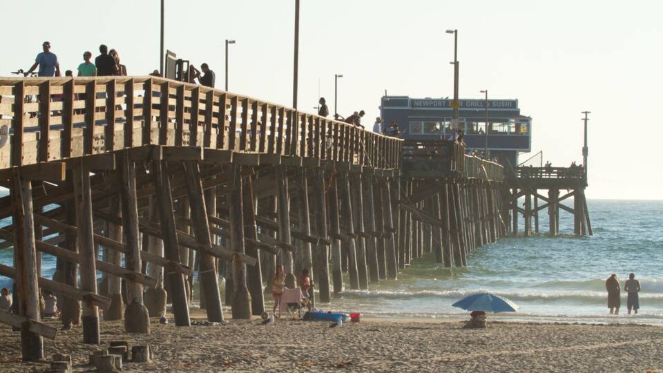 A wooden pier extending into the ocean with people walking along it.