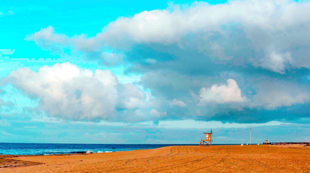 "P" Street, guard tower stands in solitude along an empty shore at the end of the Balboa Peninsula under stormy skies.