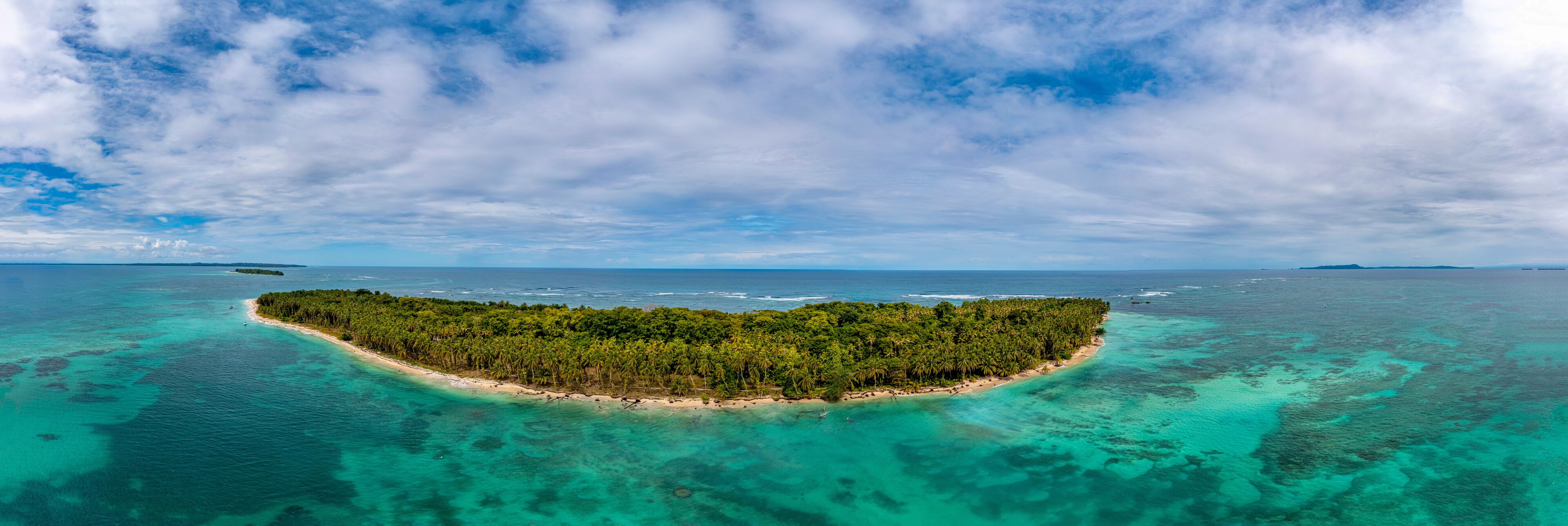 Breathtaking aerial drone view showing the lush green vegetation and white sandy beaches of Zapatillas Island in Panama