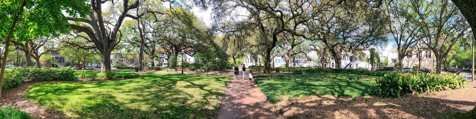 SAVANNAH, GA - APRIL 2ND, 2018: Tourists walk along beautiful city park, panoramic view. - Panoramic view