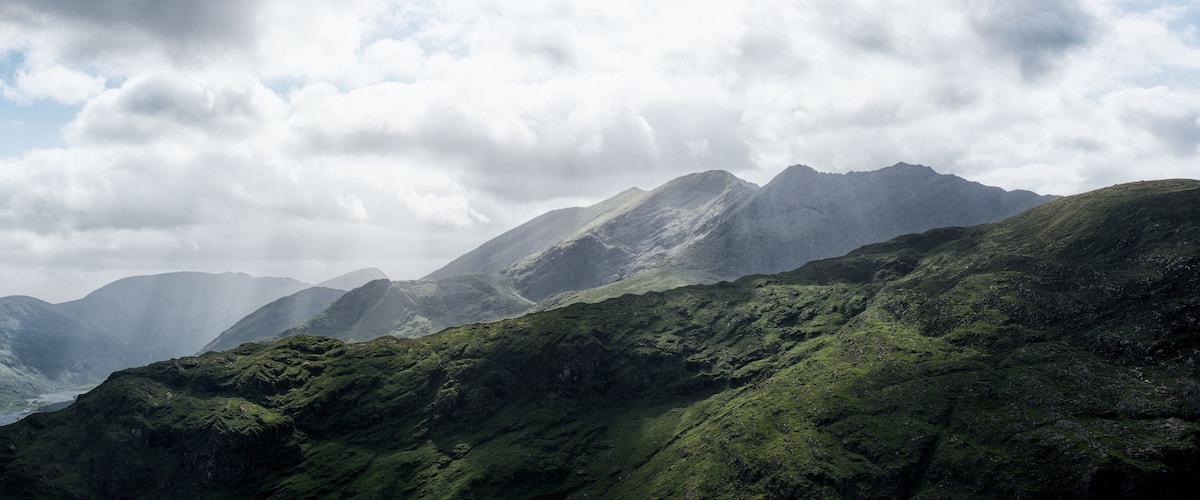 A mountainous landscape with lush green hills and a valley.