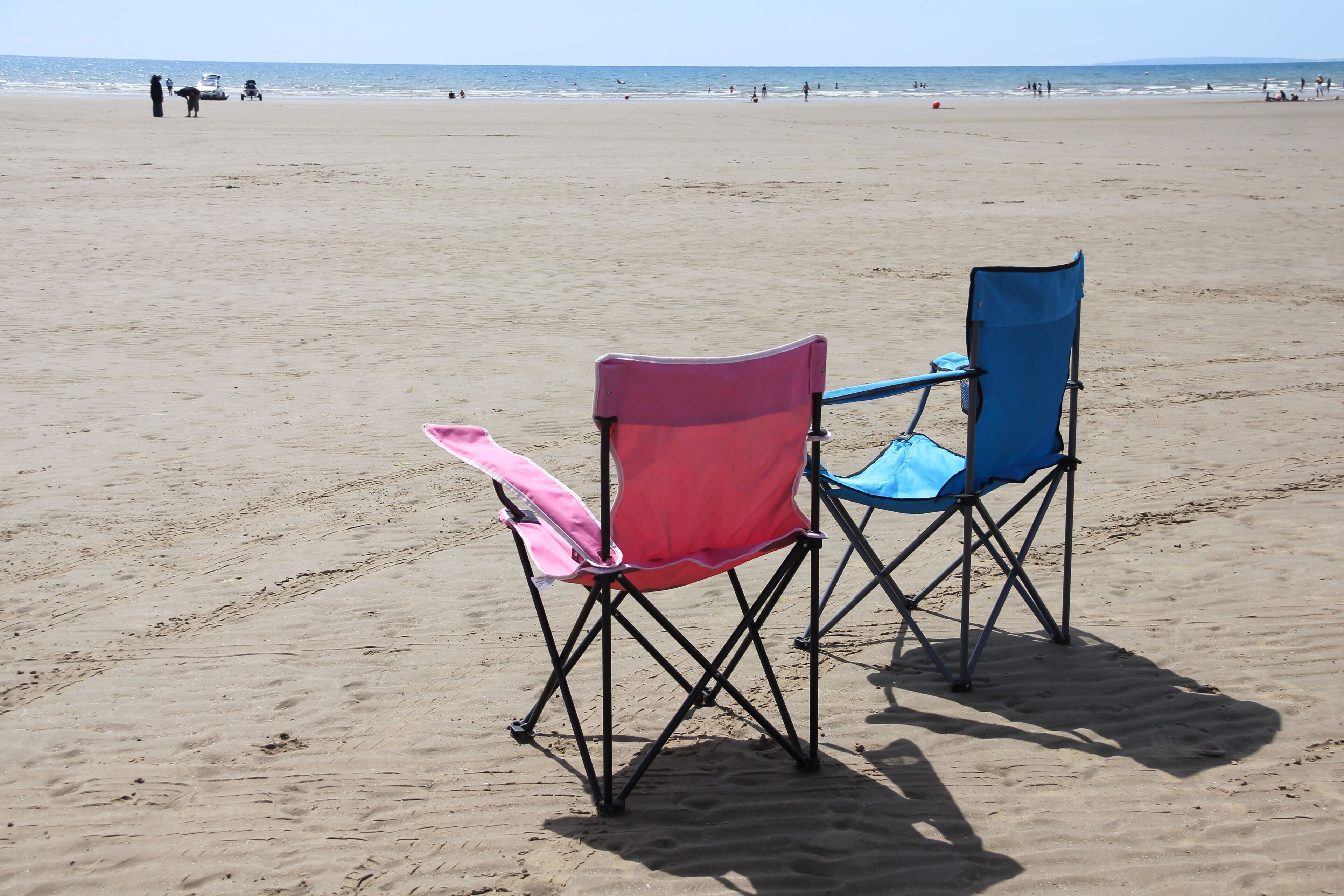 His and her pink and blue sun chairs on beach at Porthmadog Wales 