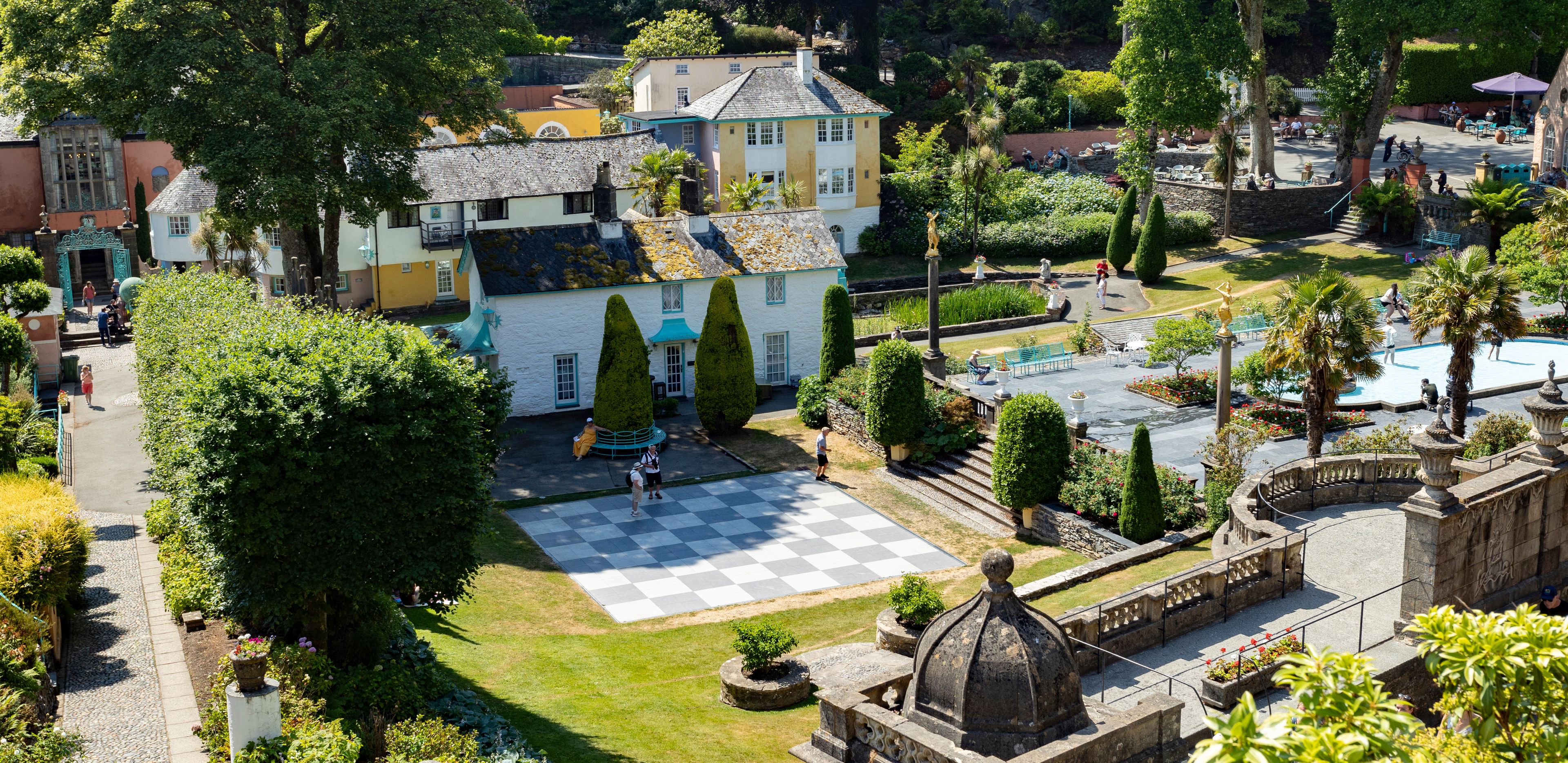 A courtyard with a checkered floor, a fountain, and a statue.