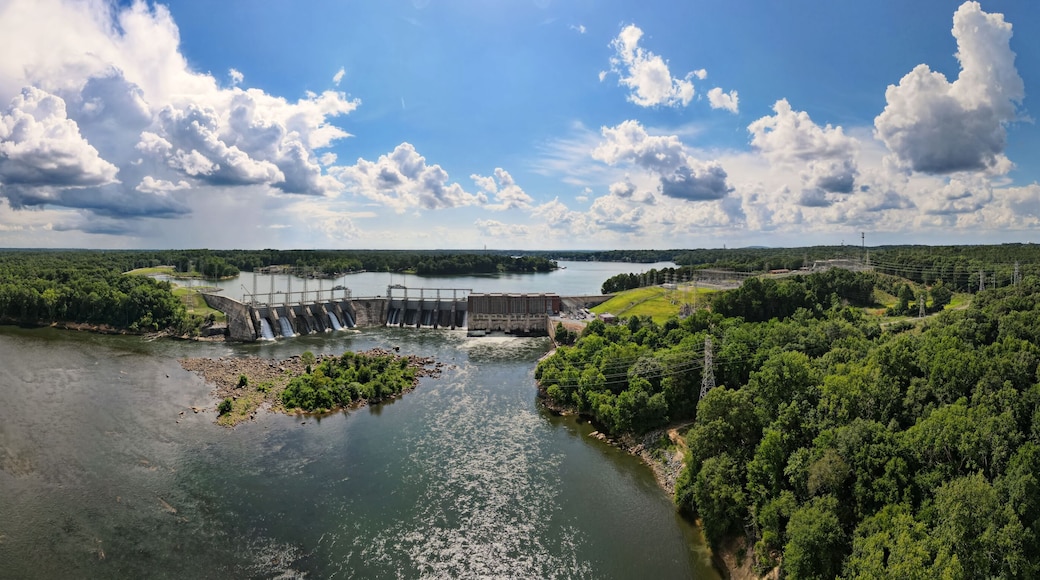 An aerial 180 degree panoramic view of a large dam and hydroelectric plant on the Catawba river in South Carolina with Lake Wylie in the background.