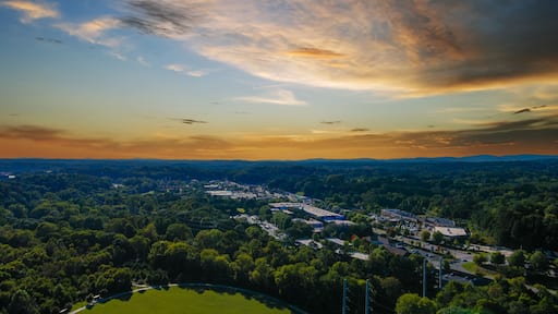an aerial shot of the vast miles of lush green trees and grass with buildings nestled among the trees and powerful clouds at sunset at Etowah River Park in Canton Georgia USA