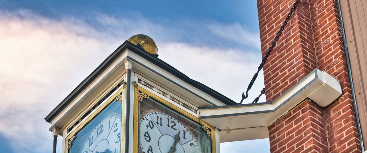 A clock in downtown Fostoria, on the corner of the Foster Block building, in northwestern Ohio. USA 2025