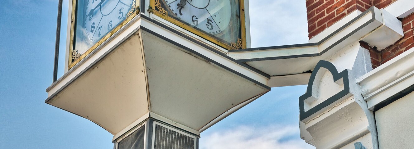 A clock in downtown Fostoria, on the corner of the Foster Block building, in northwestern Ohio. USA 2025