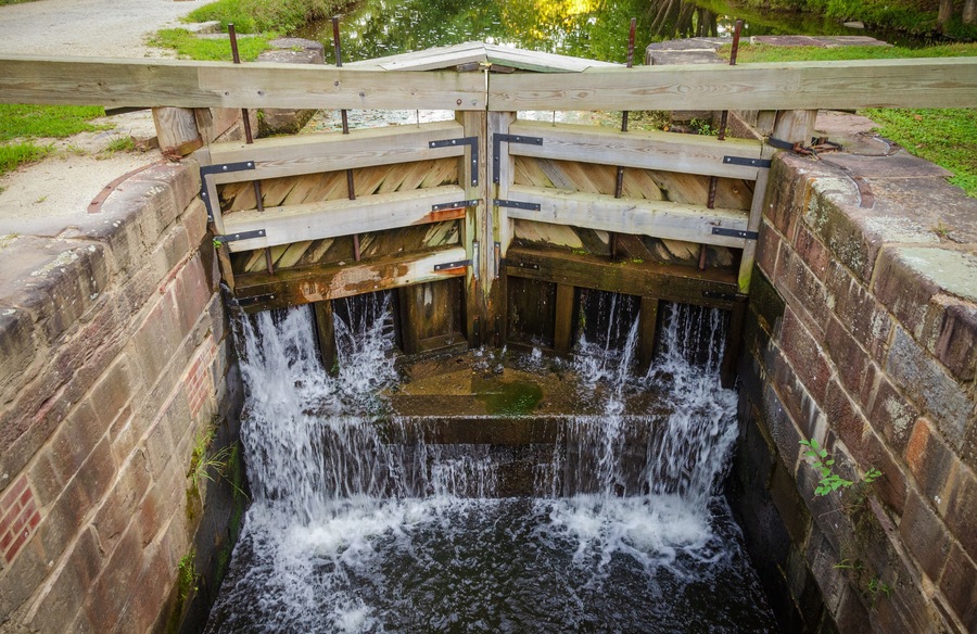 Une structure en bois avec un canal d’eau en dessous.