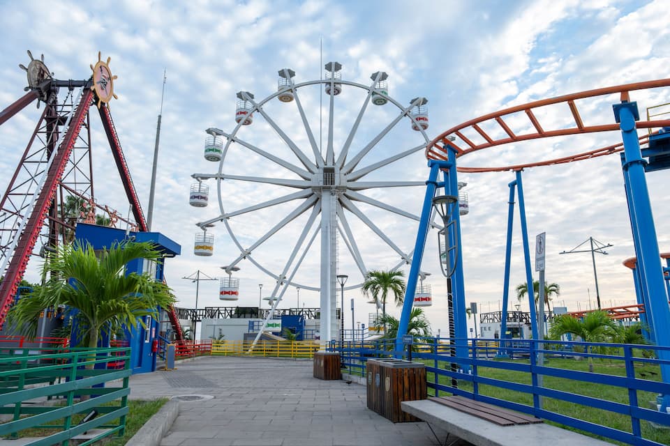 A Ferris wheel, a roller coaster, and a Ferris wheel structure at an amusement park.