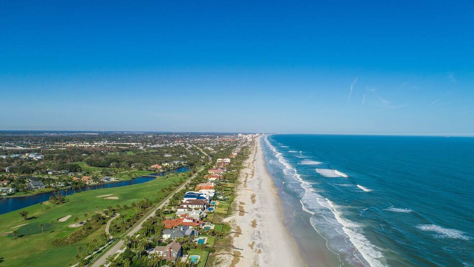 A coastal town with a beach, ocean, and golf course.