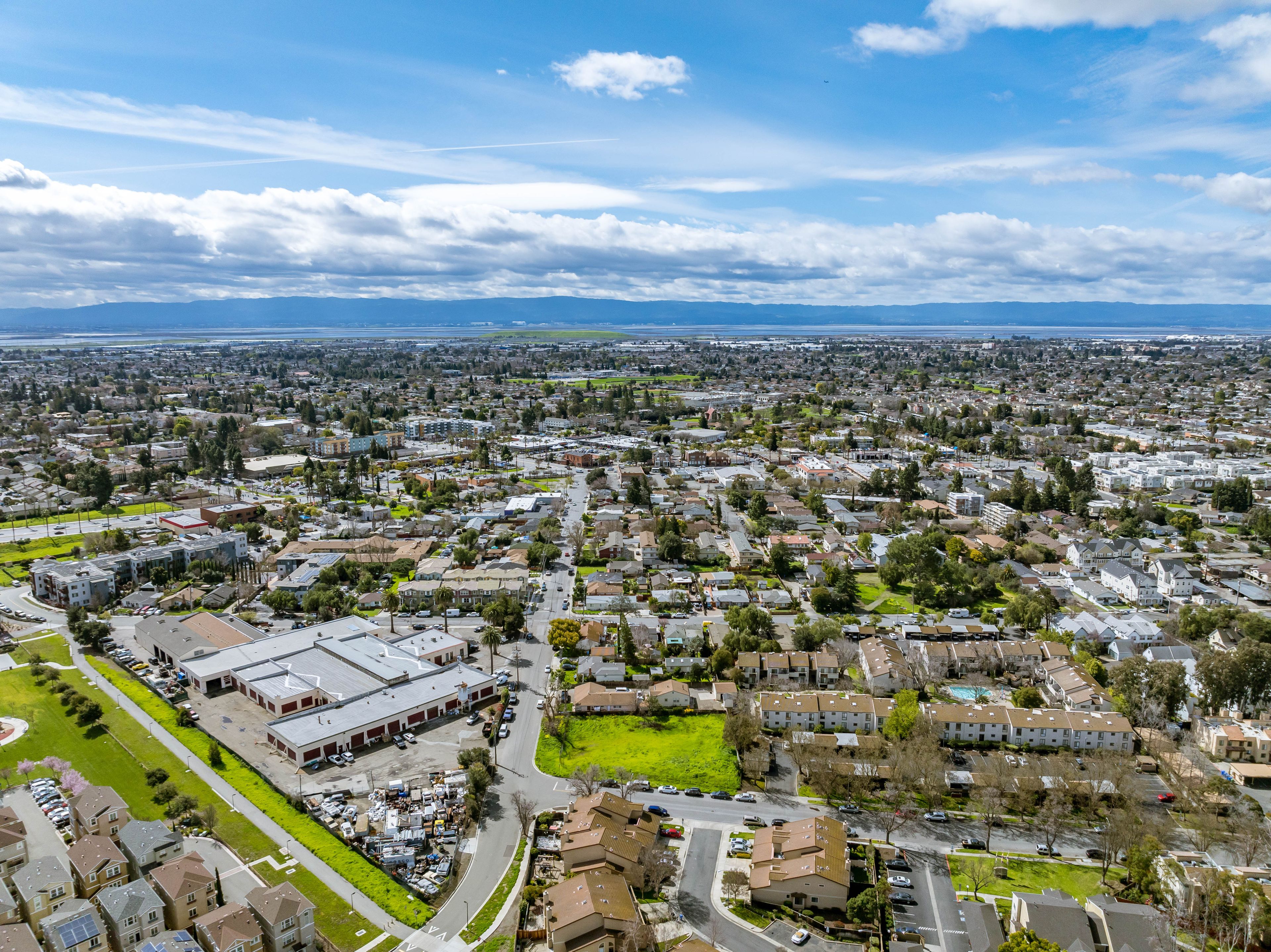 A cityscape with residential areas, roads, and a distant mountain range.