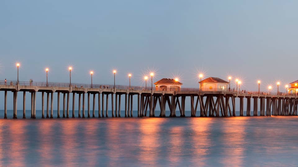 A pier with multiple structures and lights extending into the water.