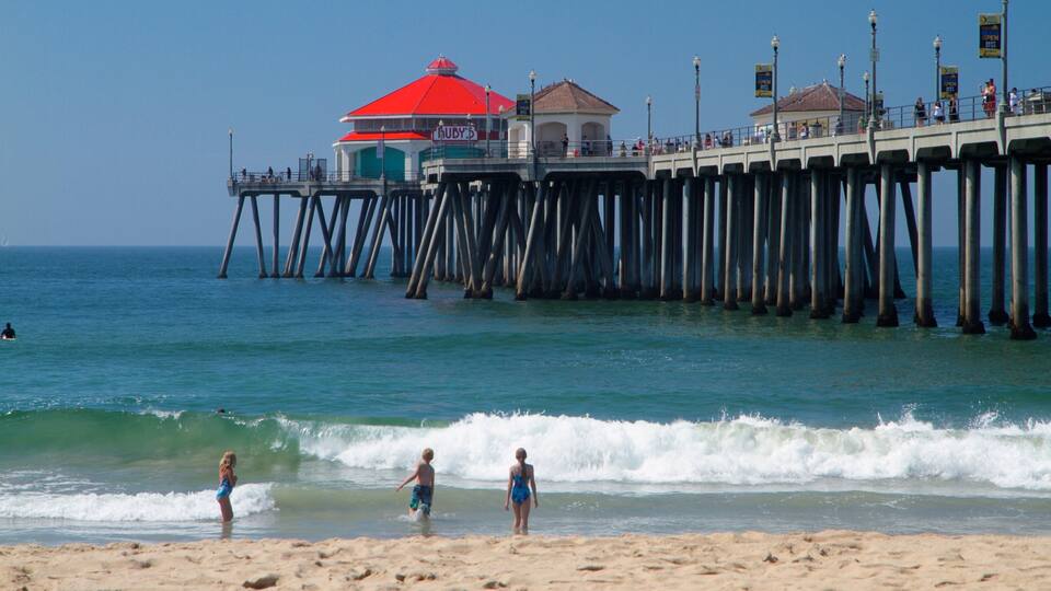 Huntington Beach showing landscape views and a beach as well as a small group of people