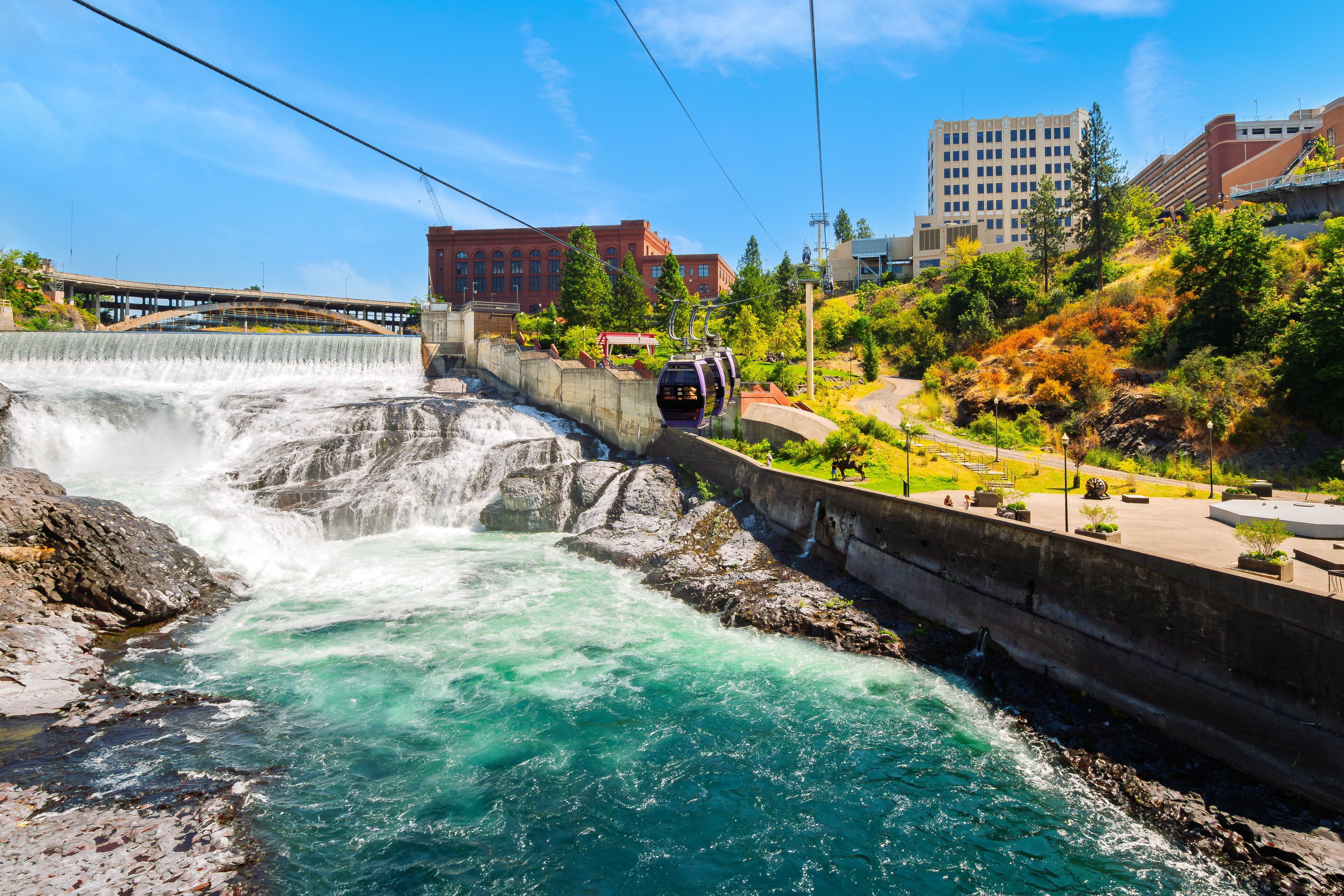 Gondolas pass over the Spokane River and Lower Falls at Huntington Park in downtown Riverfront Park, Spokane Washington State.