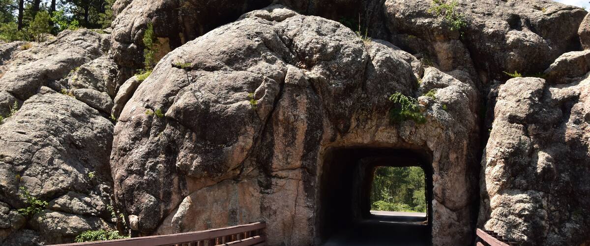 A large rock formation with a tunnel entrance.