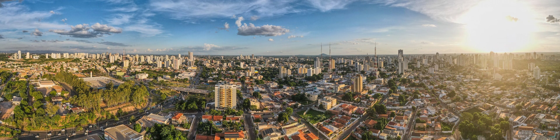 A panoramic view of a city with dense urban development, a prominent bridge, and a clear sky.